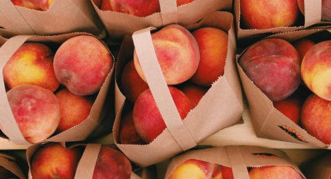 peaches in brown kraft tote bags