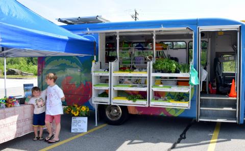 Two boys browse the market’s offerings before making a purchase.