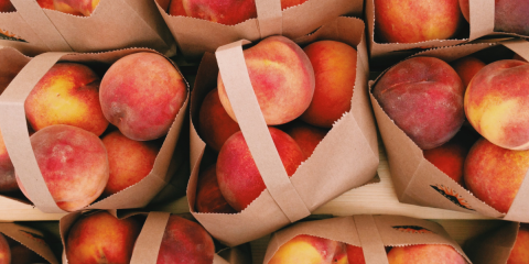 peaches in brown kraft tote bags